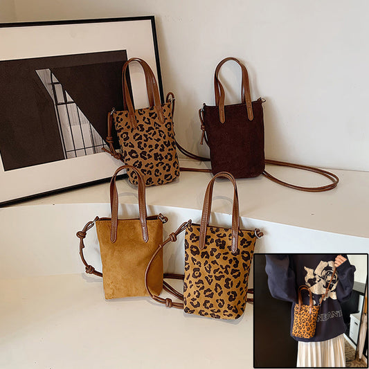 Four handbags with leopard print and brown leather straps on a white surface.