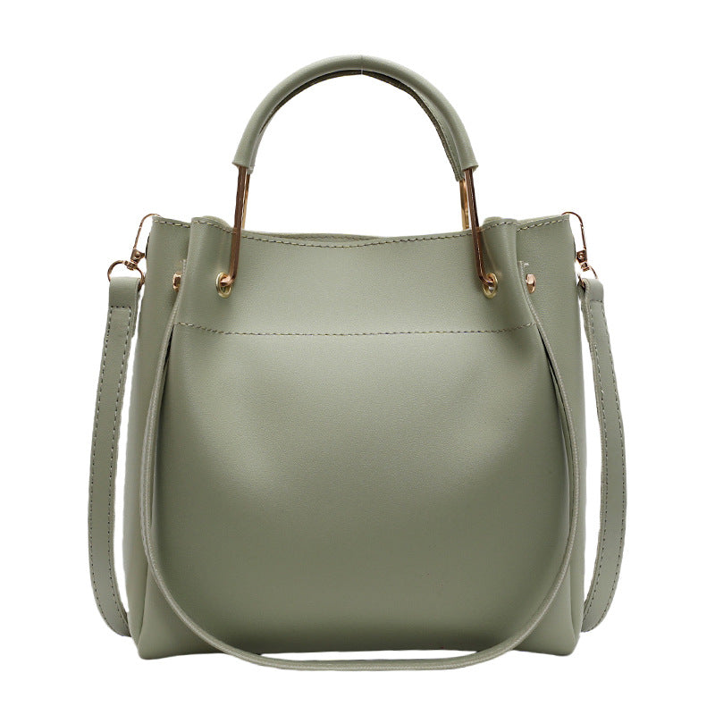 Green handbag with a strap on a white background