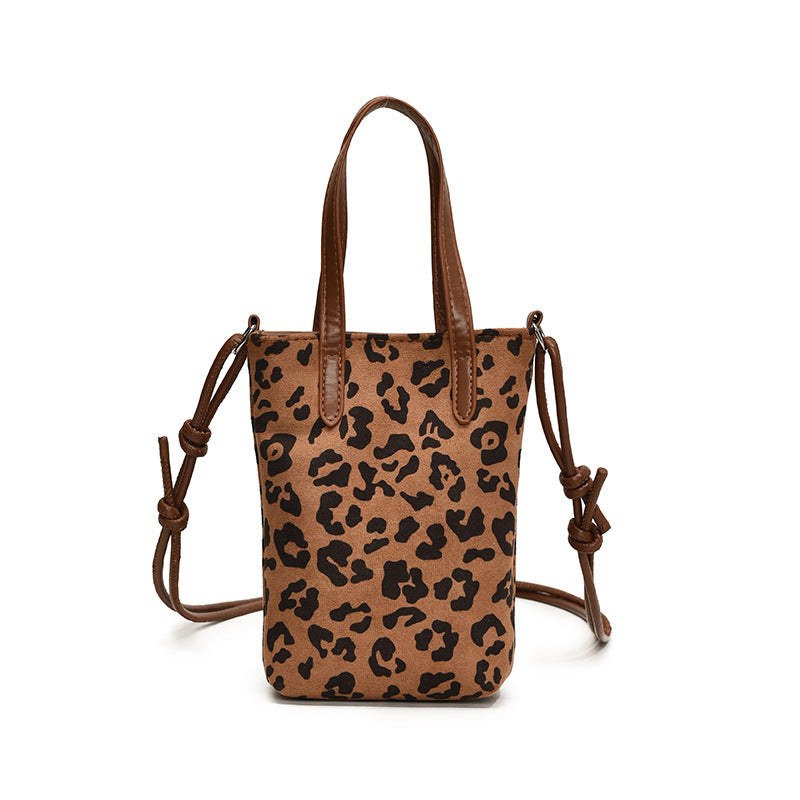Leopard print handbag with brown straps on a white background